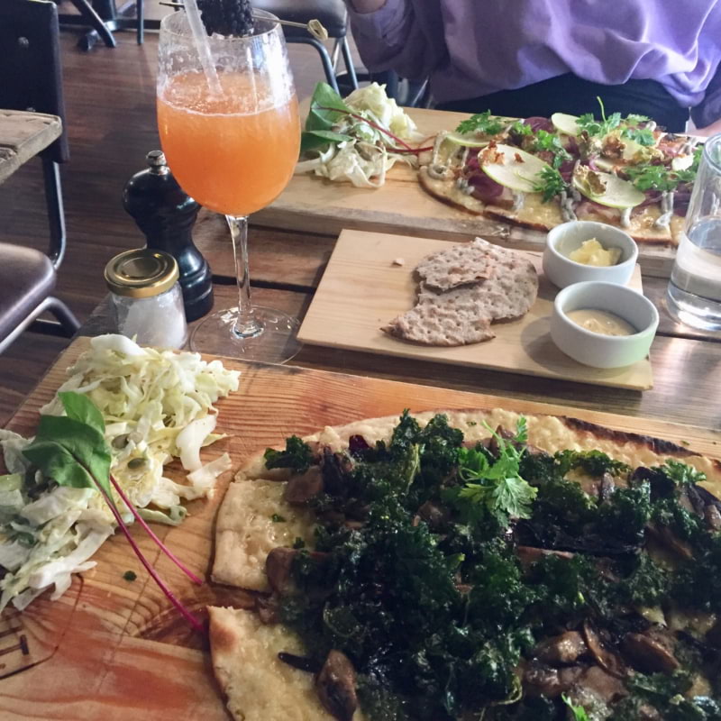 Grönkålspizza och alkoholfria drinken Kråkan.  – Bild från Knut Regeringsgatan av Caroline L. (2020-08-08)